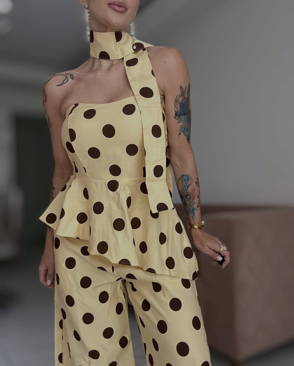 Núbia com conjunto amarelo de bolinhas marrons e lenço no pescoço